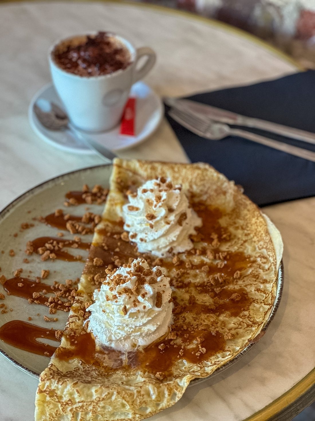 Une crêpe de froment nappée de caramel au beurre salé, garnie de chantilly et de brisures de spéculoos